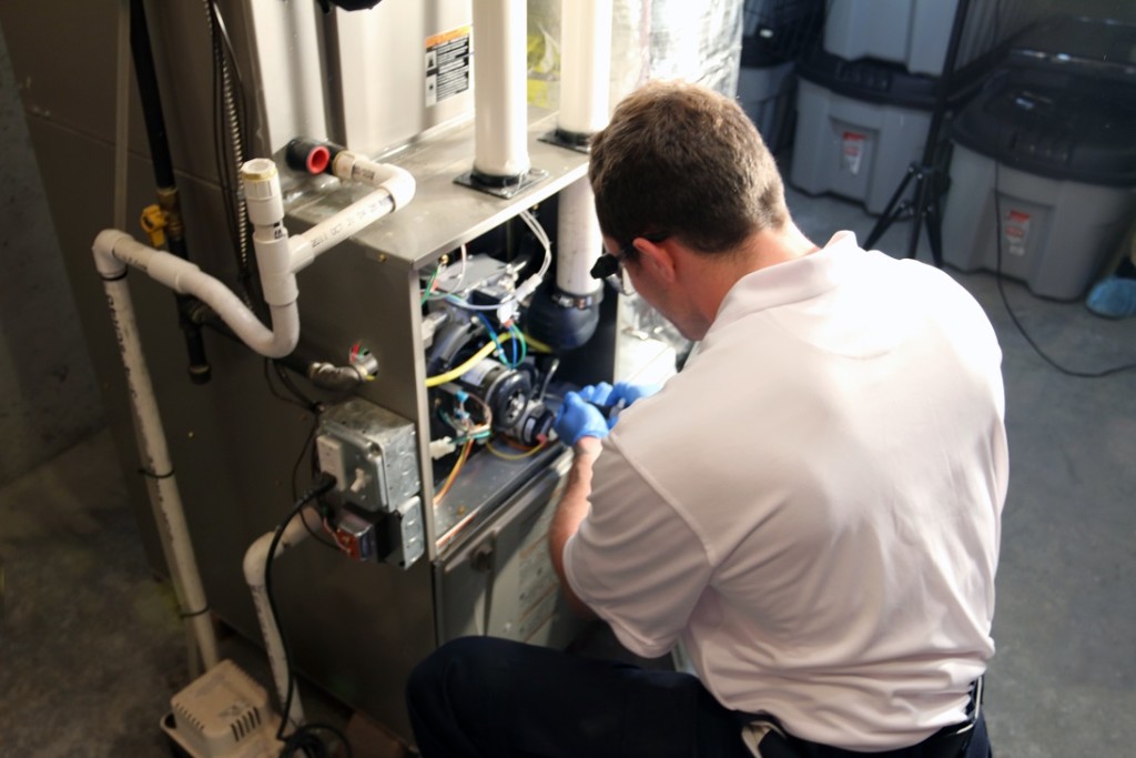 man fixing a furnace